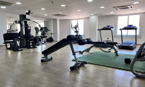 A Juffair apartment for sale, featuring a gym room with a treadmill and other exercise equipment.