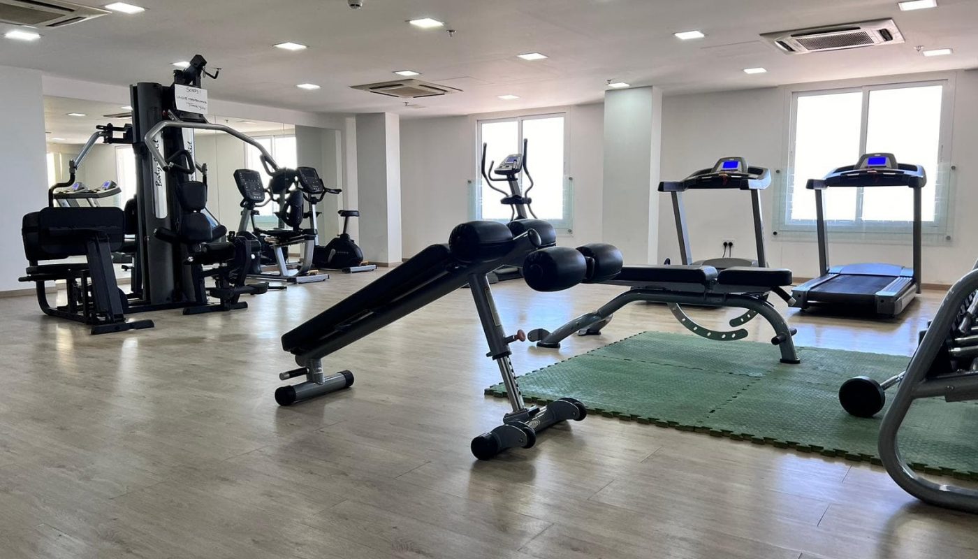 A Juffair apartment for sale, featuring a gym room with a treadmill and other exercise equipment.