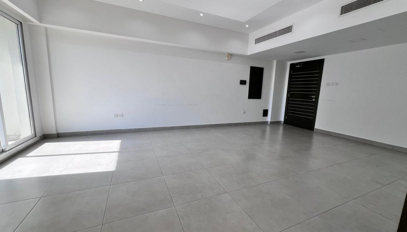 A vacant apartment in Juffair featuring tile floors and sliding glass doors.