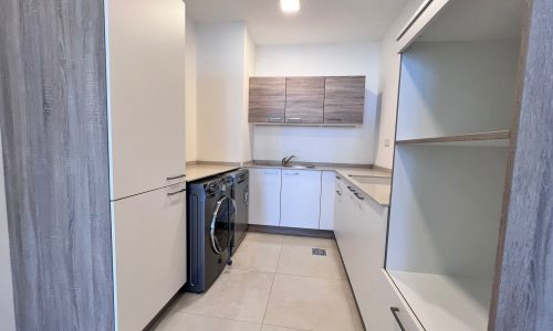 A small luxury kitchen in Juffair with a washer and dryer in a 2 bedroom apartment.