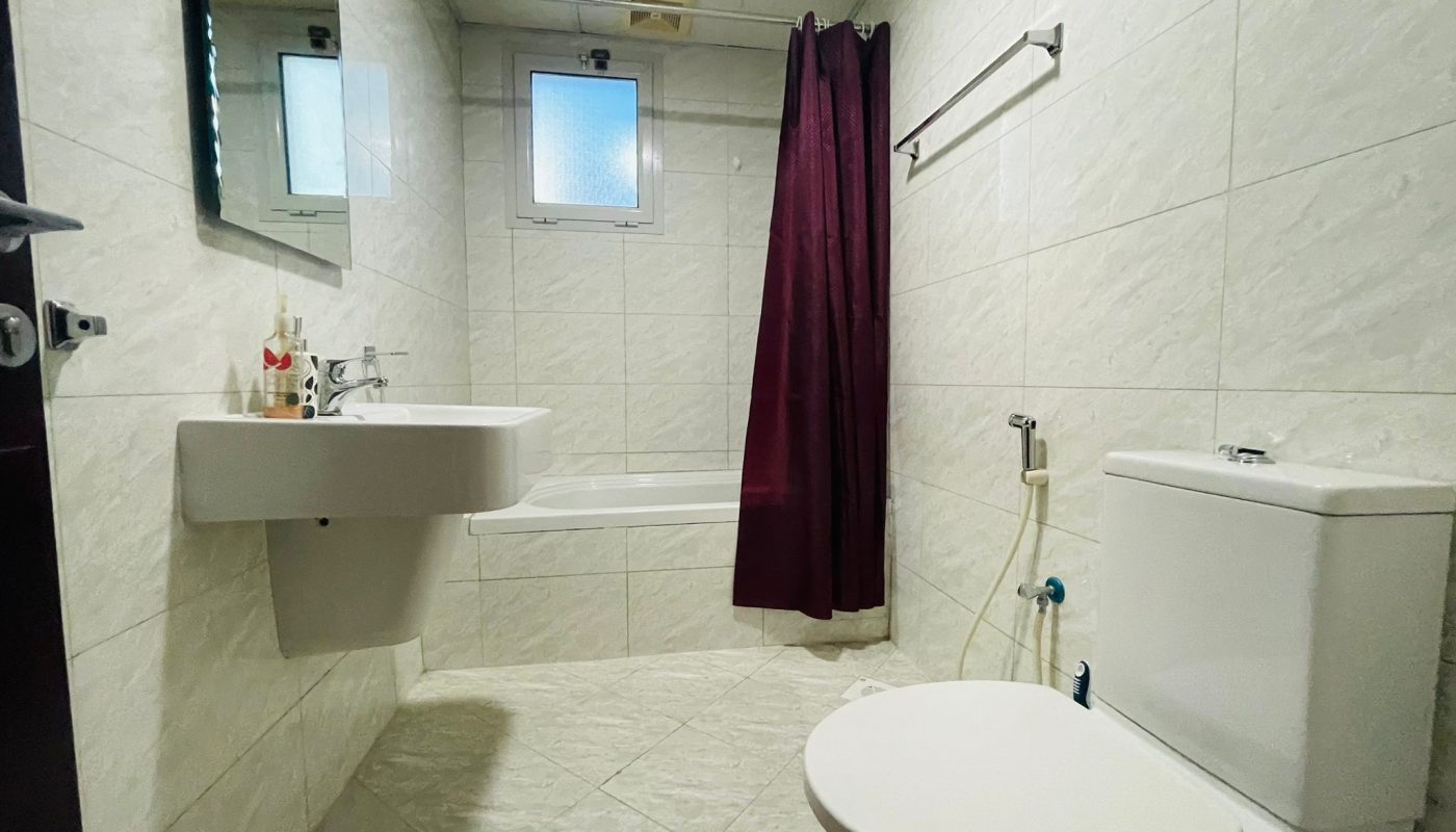 A 2BR apartment with a bathroom equipped with a toilet, sink and shower in Juffair.