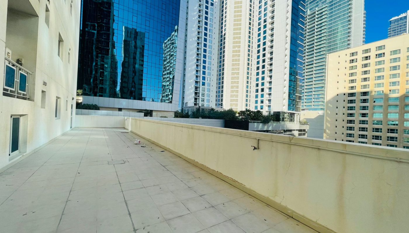 A 2BR apartment with a balcony overlooking the tall buildings of Juffair city.
