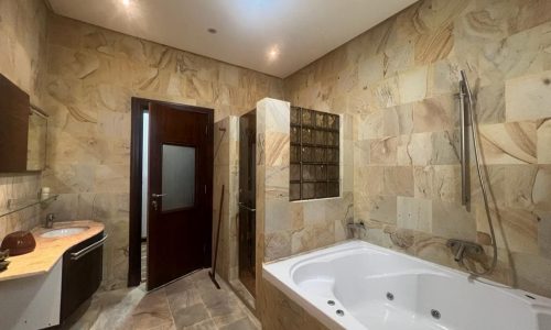 A VILLA bathroom with tiled walls and a bathtub available for RENT.