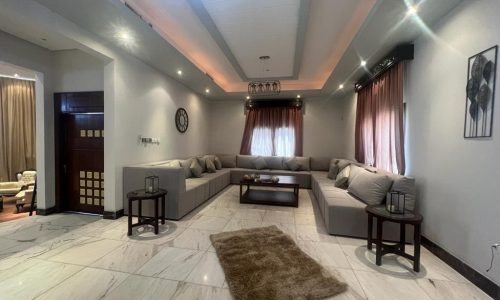 A Juffair villa for rent with a living room featuring a luxurious couch and elegant coffee table.