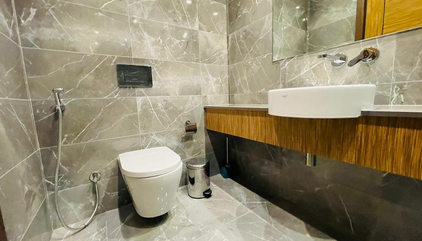 A spacious modern bathroom with a toilet and sink.