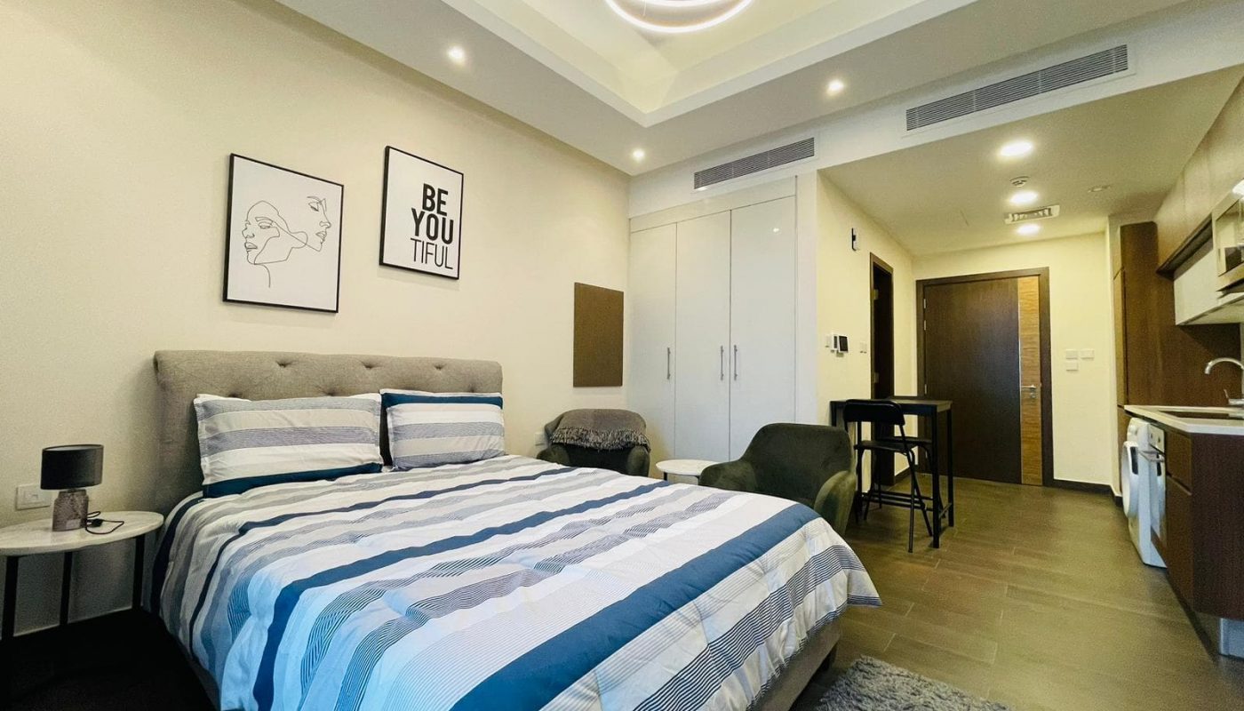 Luxury Studio in Juffair featuring a bed and a kitchenette.