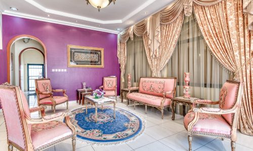 A villa in the Al-Hajiyat area with pink furniture and a purple wall.