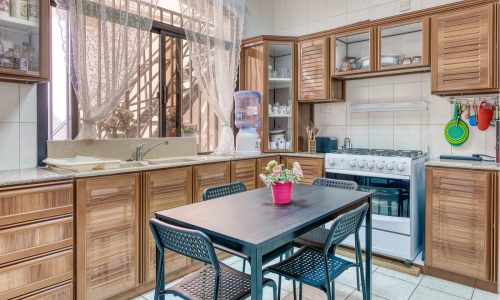 A villa kitchen with a table and chairs, available for sale at Al-Hajiyat.