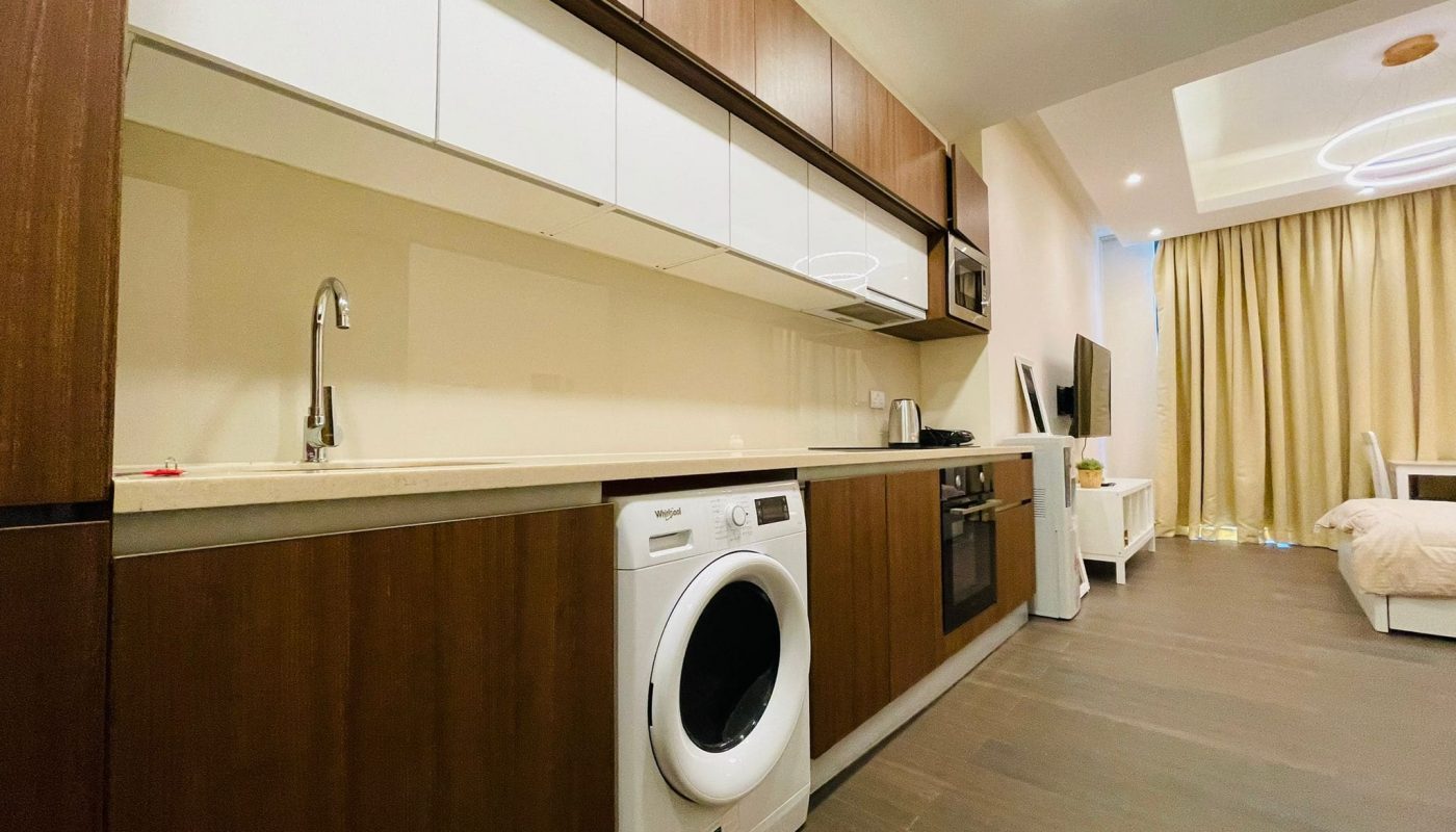 A Luxury Studio in Juffair with a modern living room, including a washing machine and a bed.