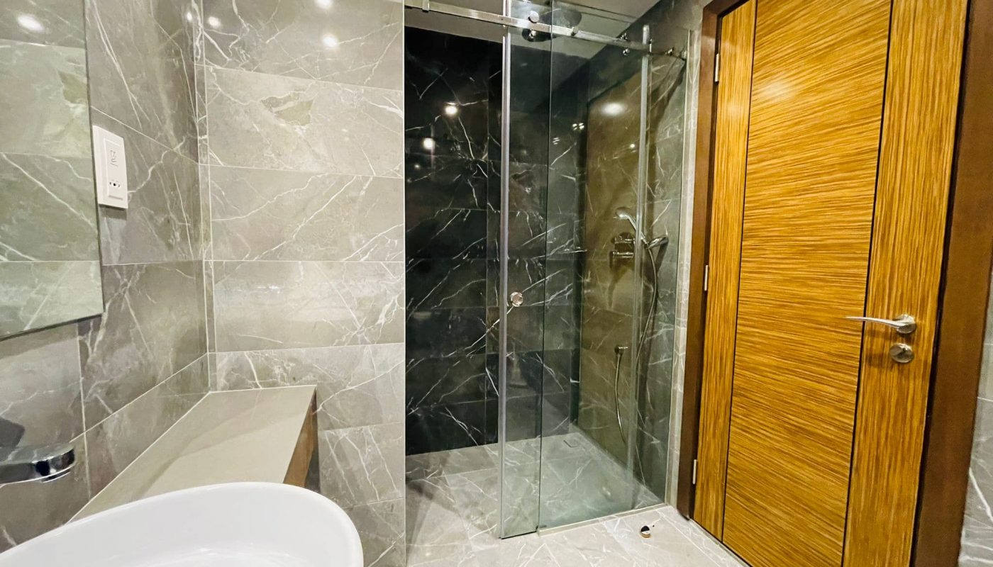 A luxury studio in Juffair with a modern bathroom featuring a glass shower door.