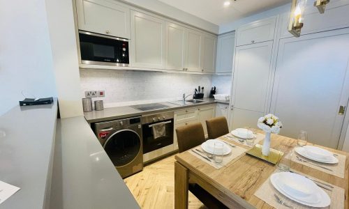 A kitchen and dining area with a washer and dryer.