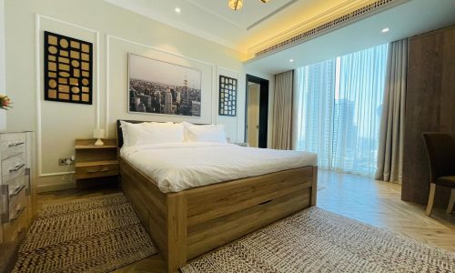 A bedroom with wooden floors and a large bed.