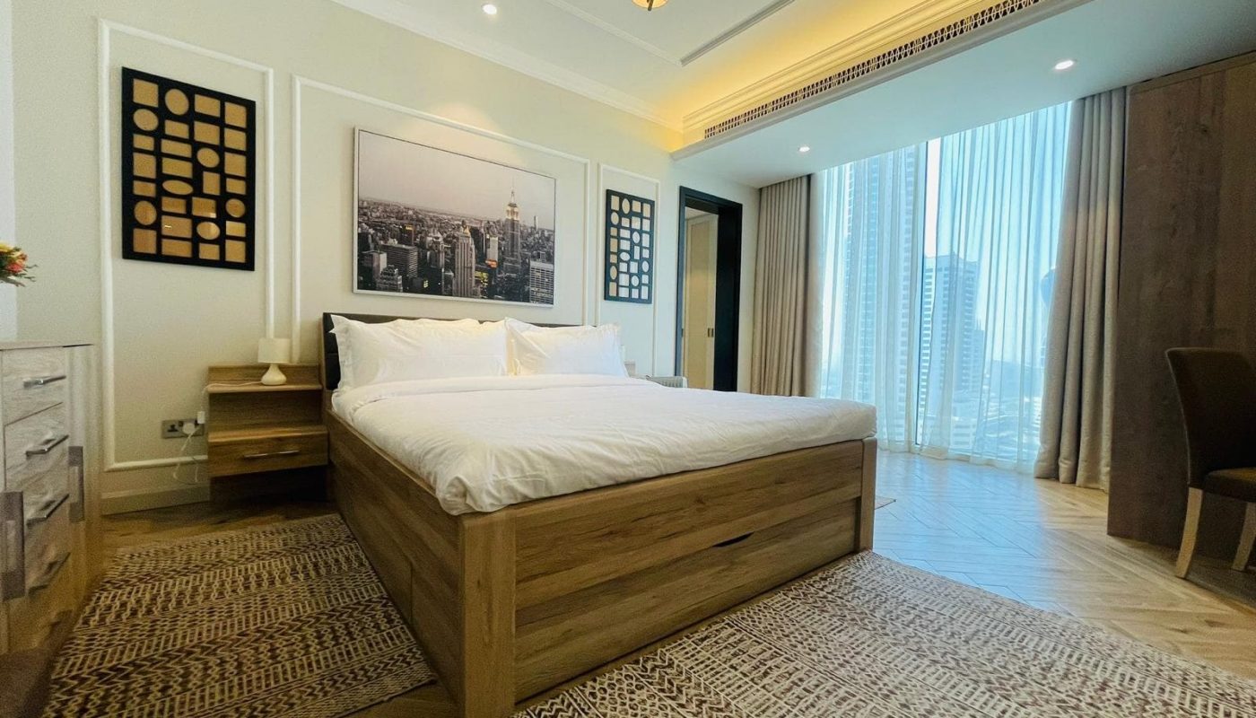 A bedroom with wooden floors and a large bed.