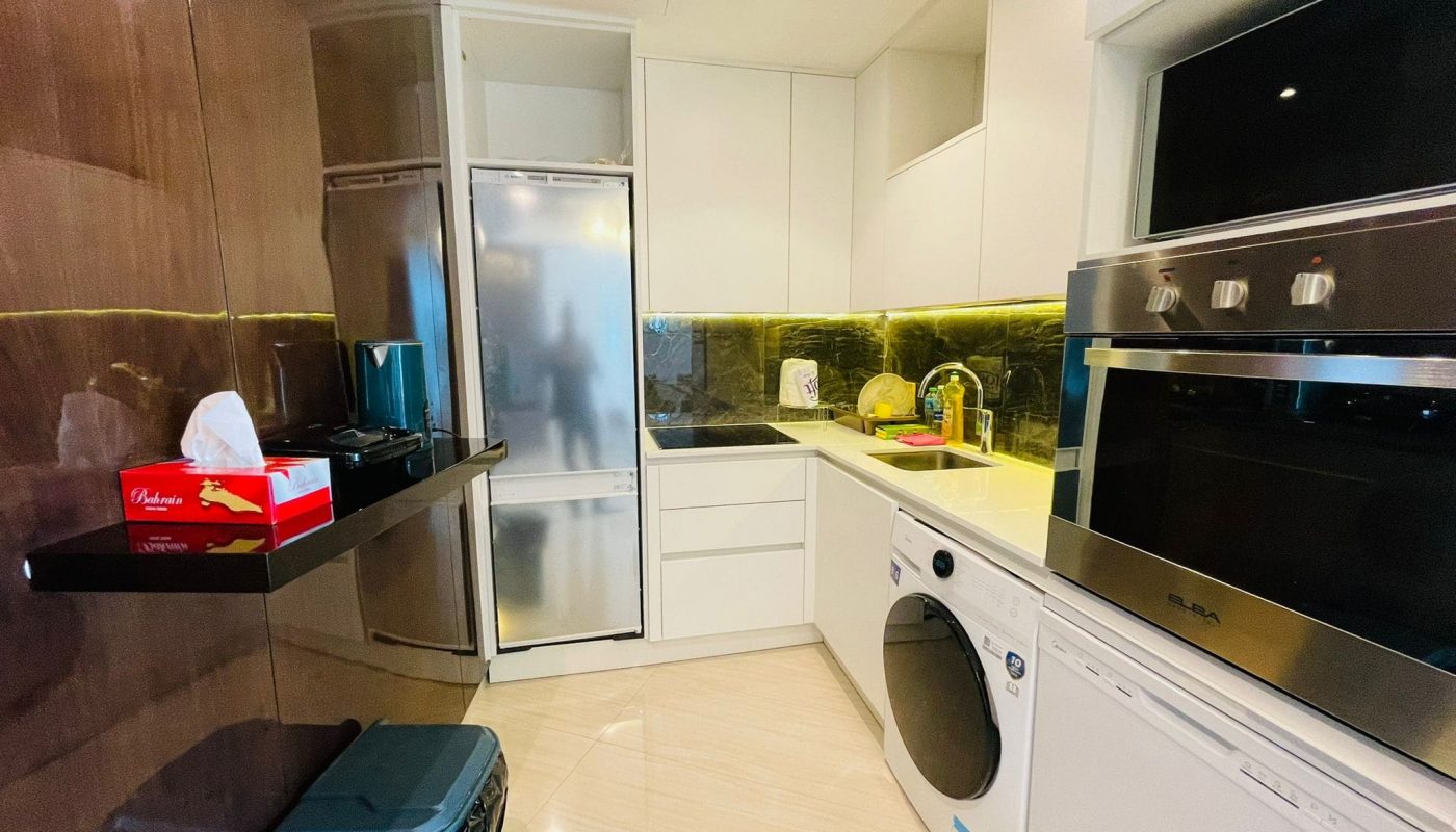 A kitchen with a washing machine and refrigerator.