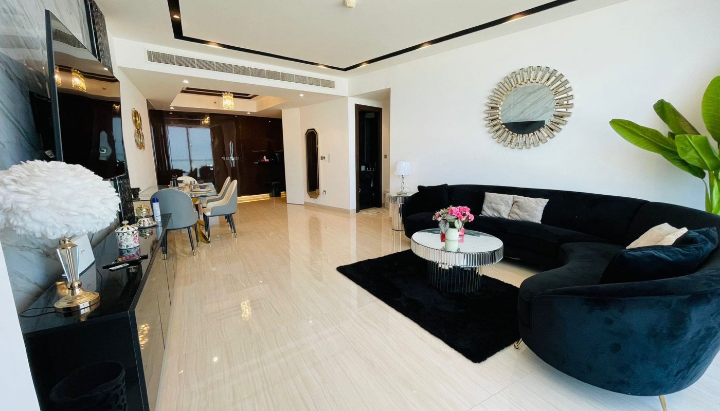 A living room with a black couch and a coffee table.