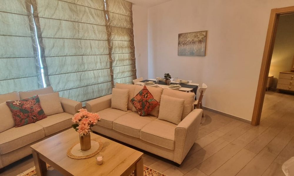 An apartment in Seef for sale with a living room featuring couches and a coffee table.