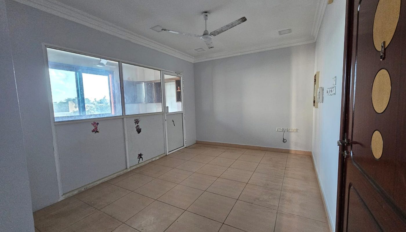 An empty flat with tile floors and a ceiling fan available for rent.