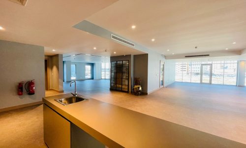 A spacious office with a sink and counter top.