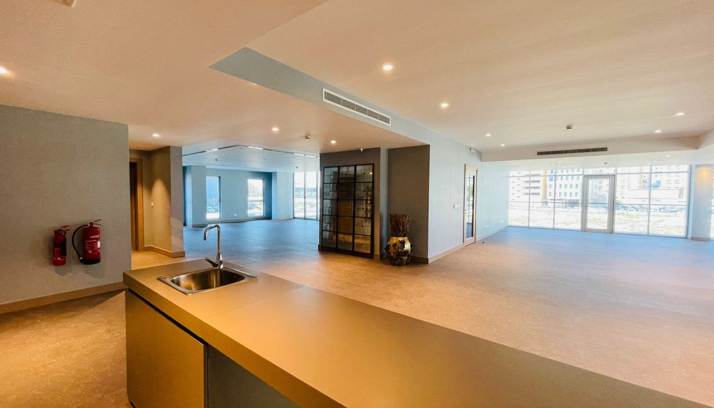 A spacious office with a sink and counter top.