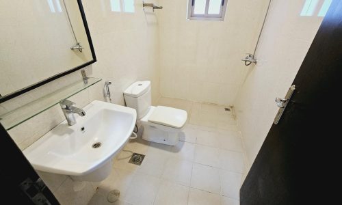 A clean and simple bathroom in a Saar apartment for rent, with a sink, toilet, and shower area.