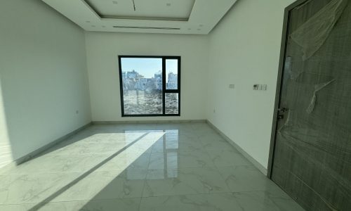 Empty room in a Modern Villa for sale with marble flooring and a large window with a city view.