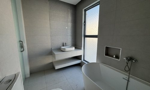 Modern Villa bathroom interior in Saraya 2, with a freestanding bathtub, floating sink, and separate shower space.