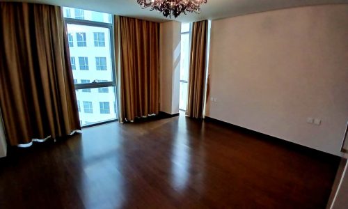 Spacious empty room with hardwood flooring, large windows with curtains, and an ornate chandelier. Auto Draft