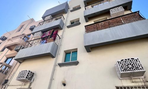 Modern urban apartment building with balconies and air conditioning units.