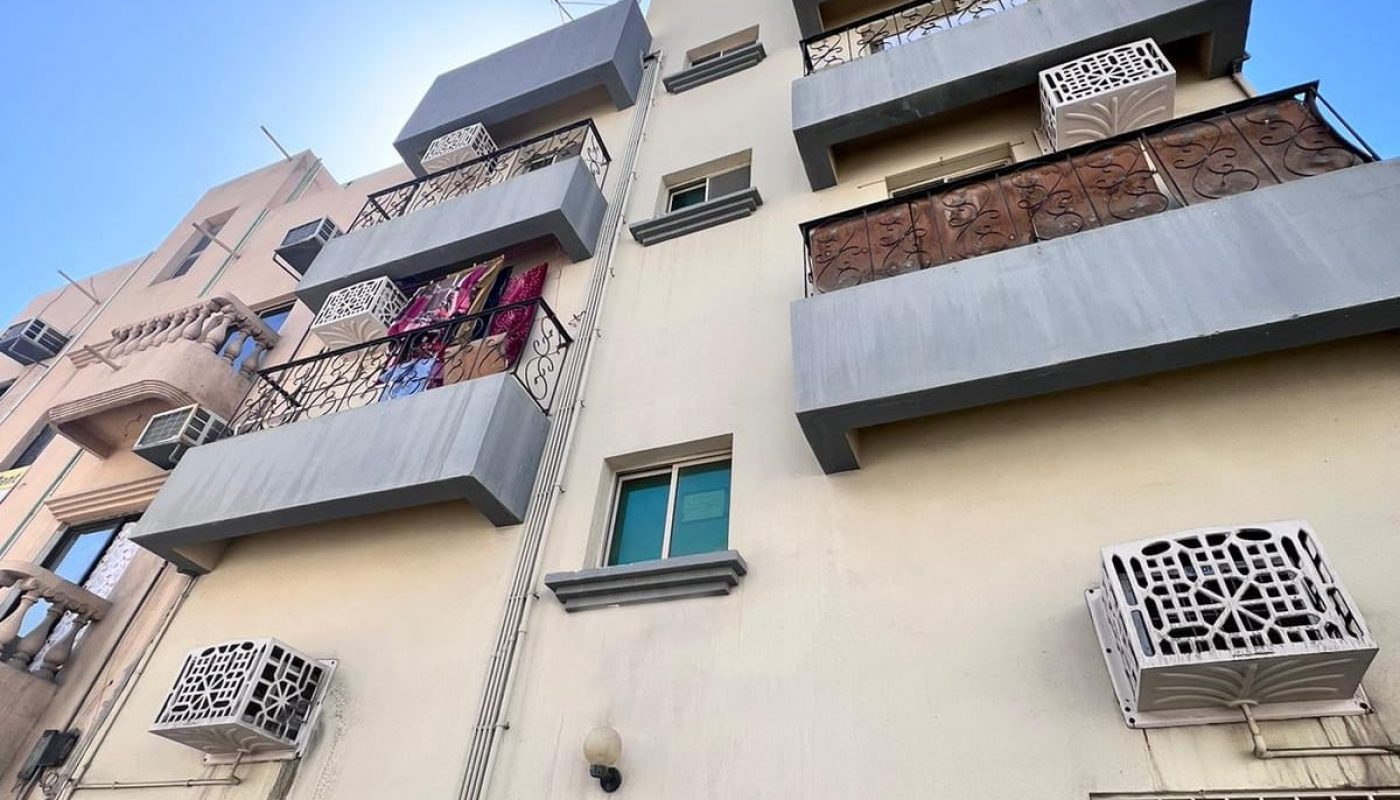Modern urban apartment building with balconies and air conditioning units.