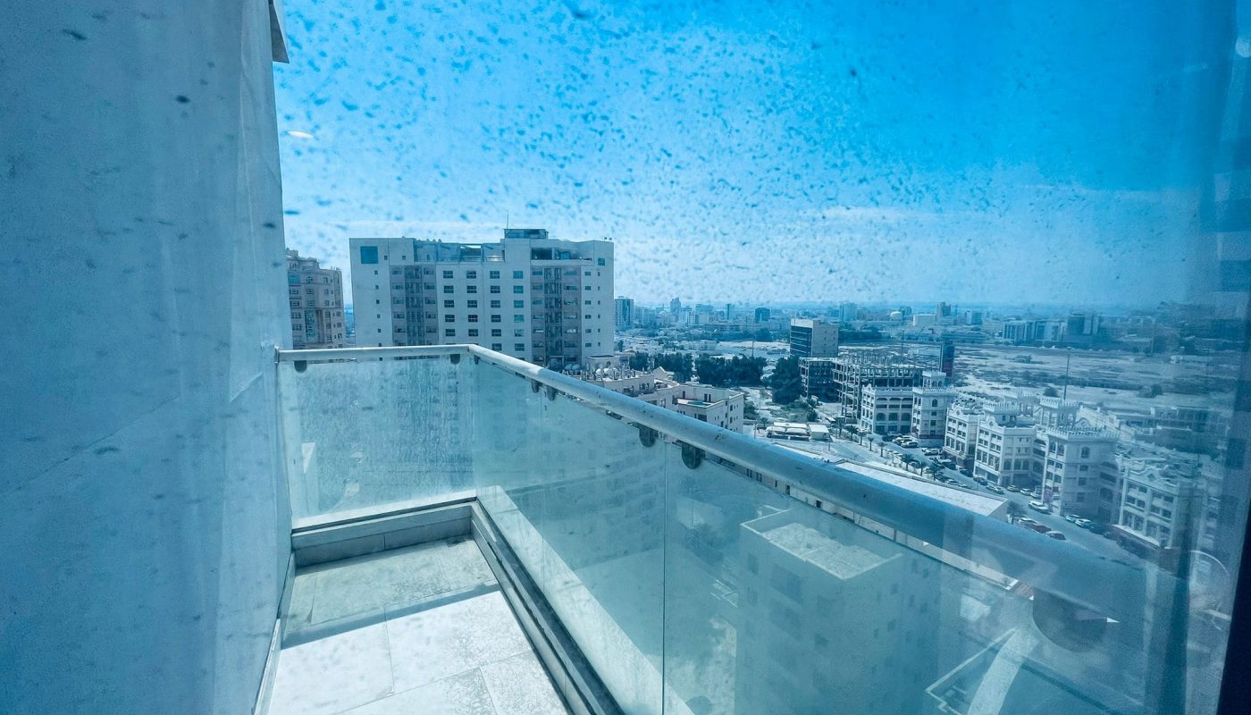 Amazing urban view from a high-rise building in Juffair with raindrops on the window.