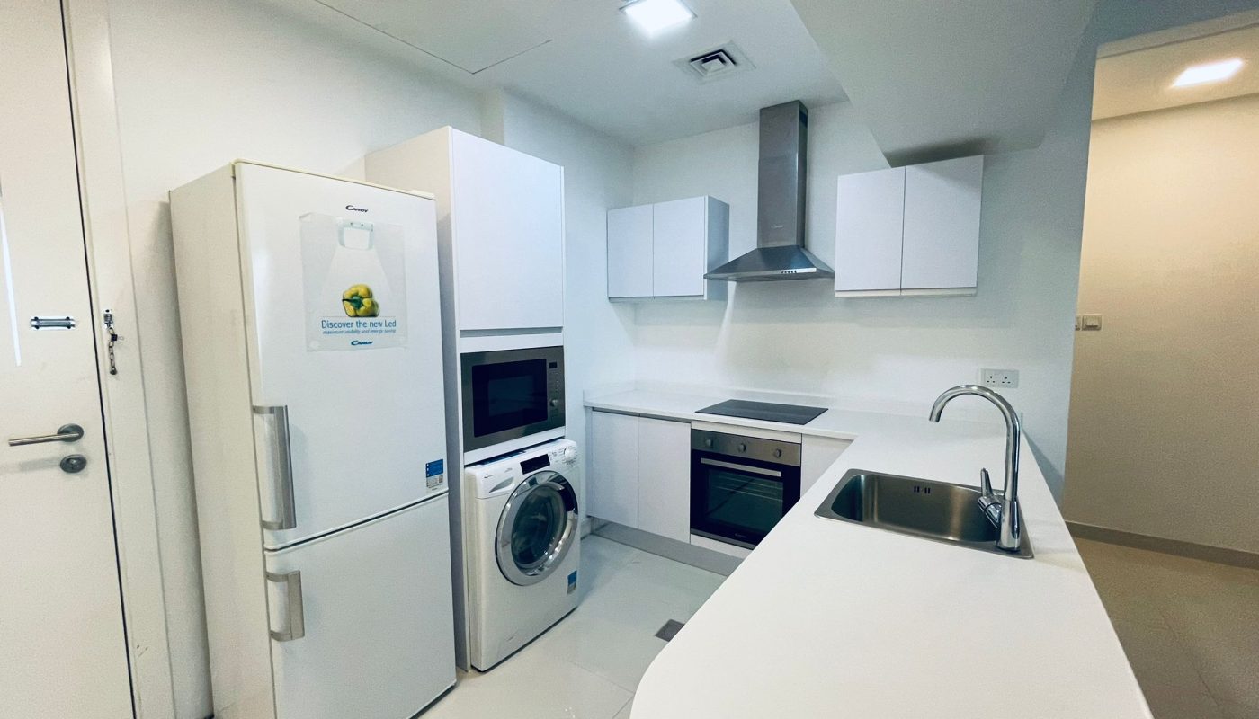 Modern kitchen interior with white appliances, including a refrigerator, oven, microwave, and washing machine, with an Auto Draft countertop.