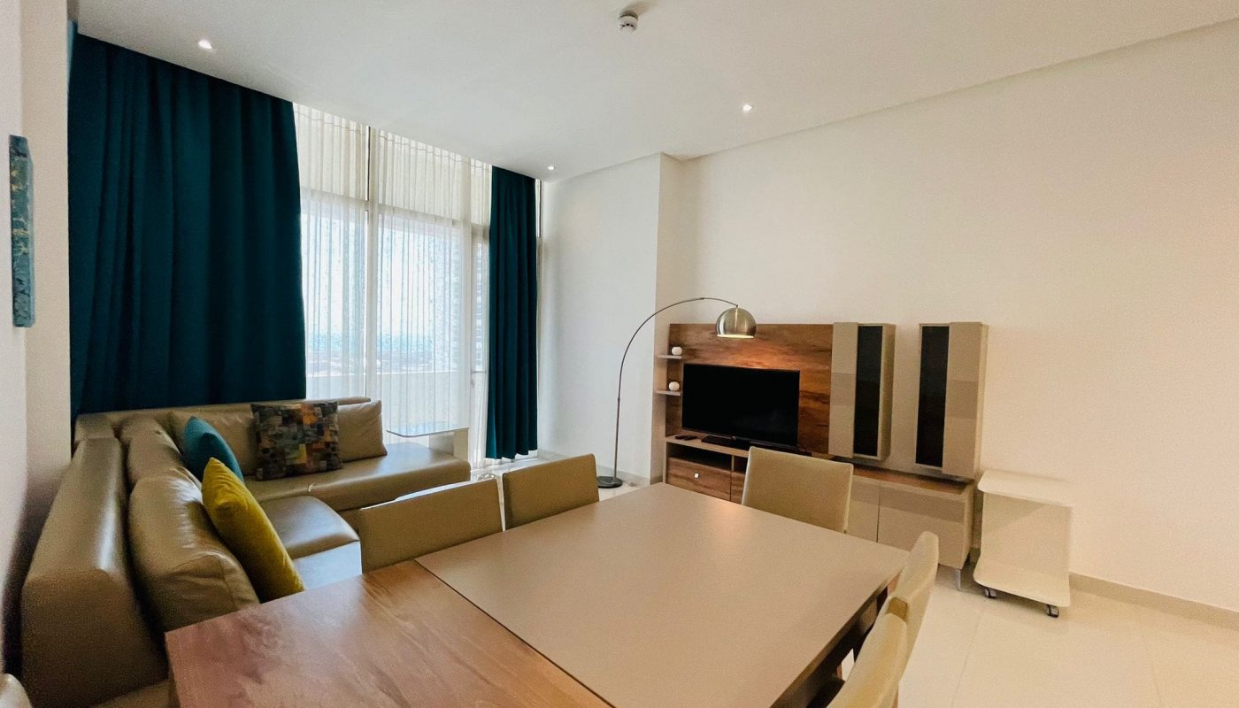 Modern living room with a large sofa, dining table, and entertainment unit. Auto Draft