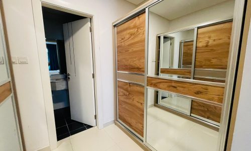 A hallway with an open door leading to a bathroom and a closed sliding wooden Auto Draft closet with mirrored doors.