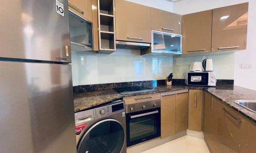 Modern kitchen with stainless steel appliances, wooden cabinets, and granite countertops.