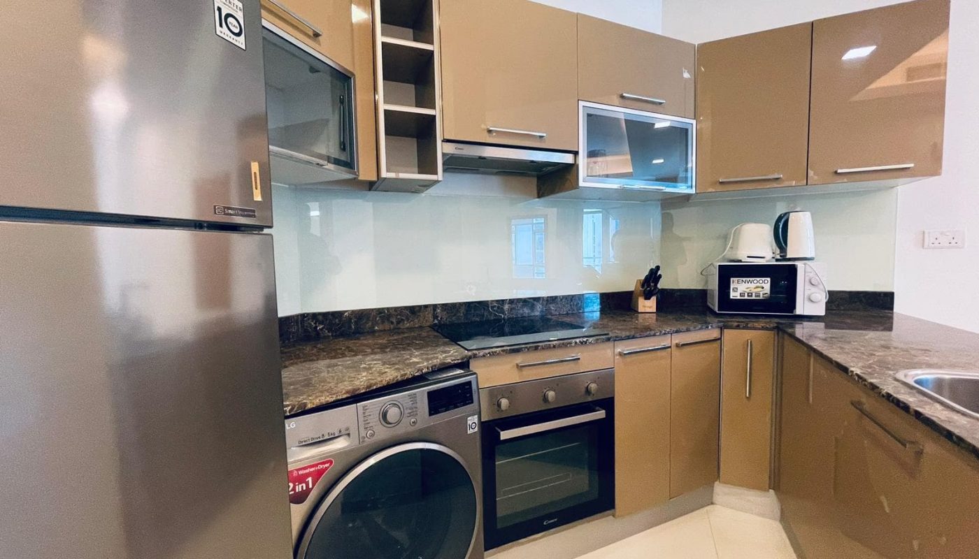 Modern kitchen with stainless steel appliances, wooden cabinets, and granite countertops.