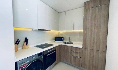 Modern kitchen interior with built-in appliances and led under-cabinet lighting.