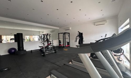 A well-equipped home gym with cardio machines and strength training equipment in the Compound Hamala Area, Villa for Rent.