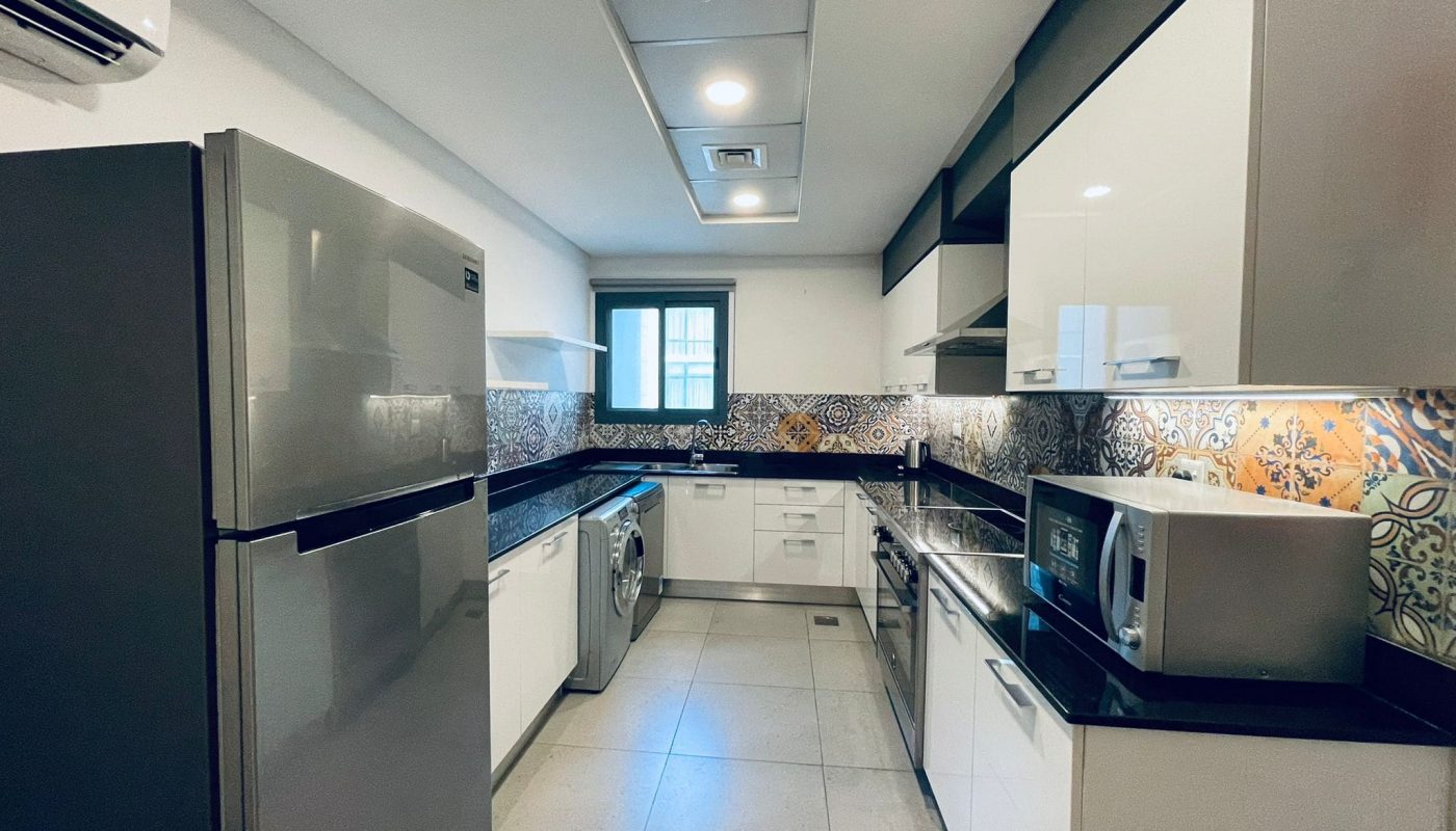 Modern kitchen interior with stainless steel appliances and Auto Draft patterned backsplash.