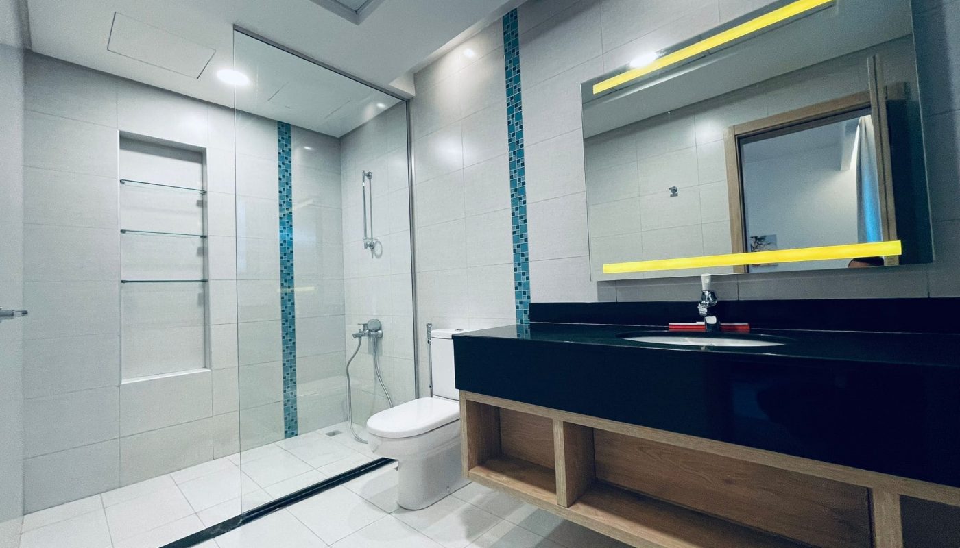 Modern bathroom interior with glass shower enclosure, vanity sink, illuminated mirror, and its subject matter focused on contemporary design aesthetics.