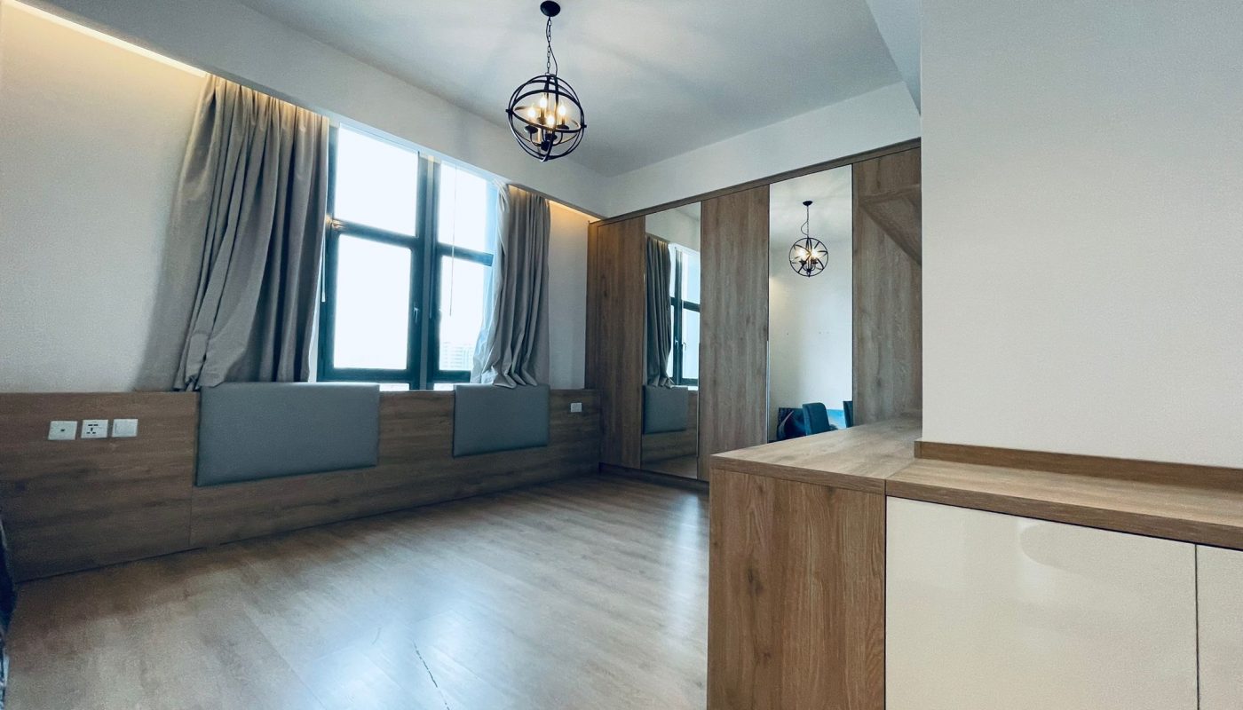 Modern minimalist bedroom with wooden floors, a large mirror, and pendant lighting. Auto Draft