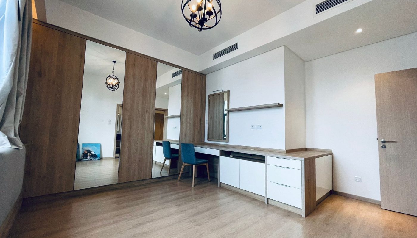 A bright, modern room with wooden floors, a desk, and spherical chandeliers becomes replete with descriptive content.