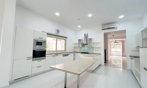 Modern kitchen interior with white cabinetry, stainless steel appliances, and a central island.