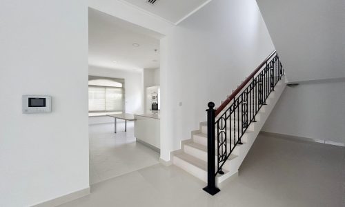 Modern "Auto Draft" interior showcasing a staircase with a black handrail and an open doorway leading to a brightly lit room.