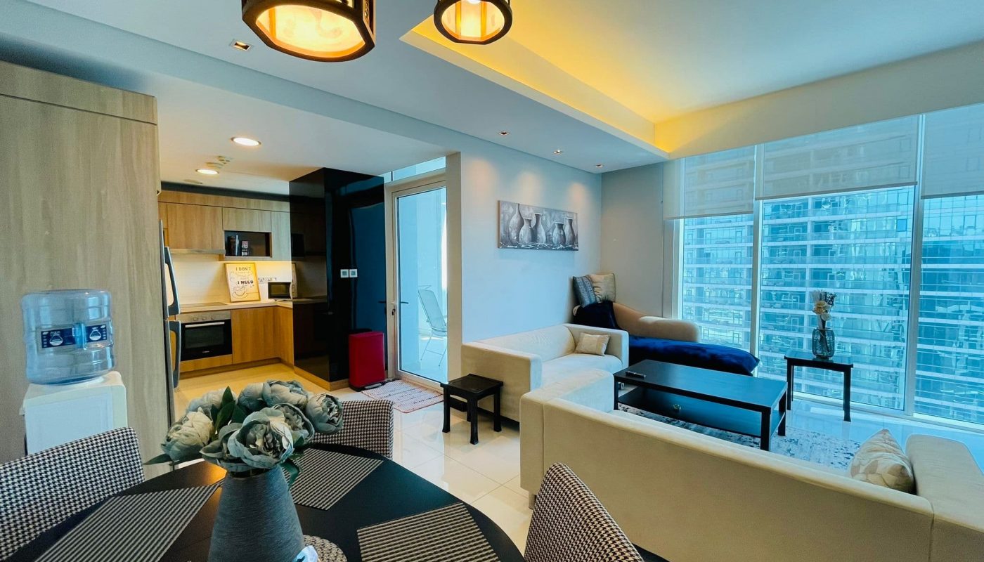 Modern 2BR apartment interior with an open-plan living and dining area, featuring contemporary furniture and large windows.