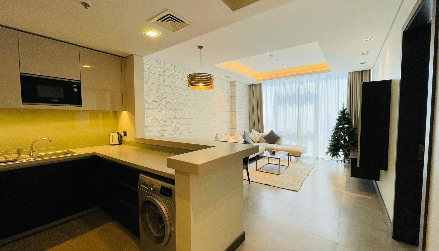 Modern apartment interior with an open-plan kitchen and adjoining living area.