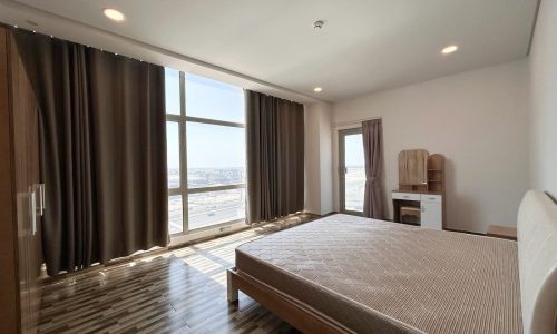 Modern bedroom with a large bed, wooden flooring, and long curtains auto-drafted open to show a view outside the window.