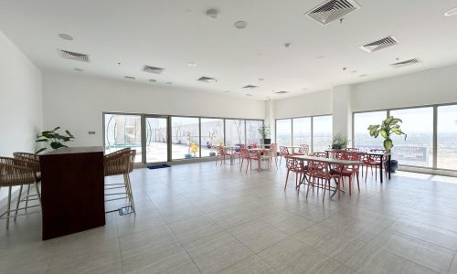 Spacious, brightly lit room with large windows and multiple Auto Draft tables and chairs.