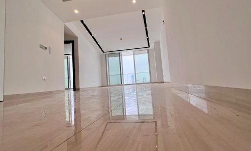 Empty modern apartment in Bahrain with glossy floor tiles and high ceiling, overlooking the Bahrain Water Bay Sea.