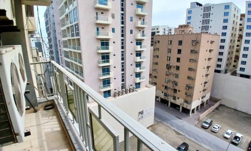 View from a balcony overlooking an urban landscape with residential buildings and auto-drafted cars.