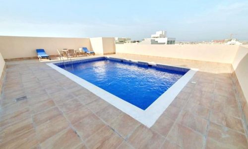 Rooftop swimming pool with sun loungers and an auto draft system, plus a city horizon in the background.